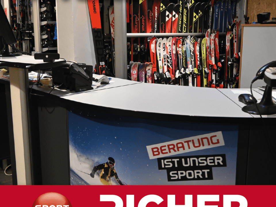 Theke mit Skiern im Hintergrund und Schriftzug 'SKIVERLEIH' sowie Werbeplakat mit Text 'BERATUNG IST UNSER SPORT' und Logo 'SPORT 2000 PICHER Kirschschlag'